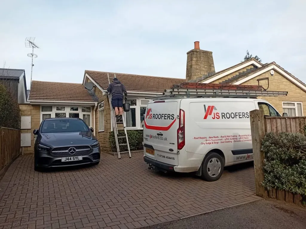JS Roofers branded van parked outside a Gloucester property under repair