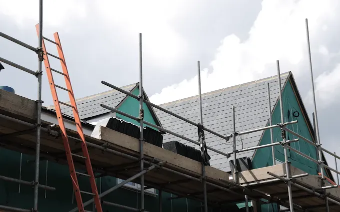 Roofer replacing broken tiles on a Gloucester terraced house